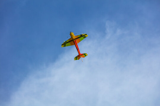 View of a colorful remote-controlled model airplane flying against a clear blue sky in Vilnius, Vilnius County, Lithuania.