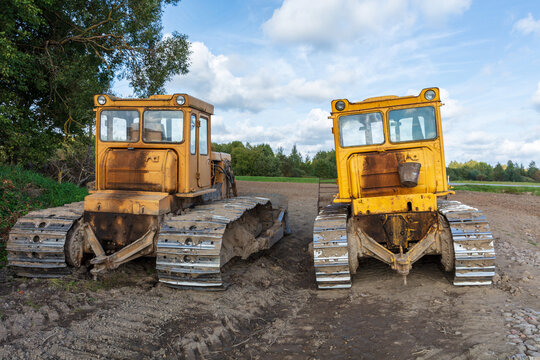 View of two yellow tracked bulldozers parked on a dirt construction site in Kelme, Siauliai County, Lithuania.