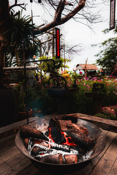 View of The Marble Mountains featuring a rustic fire pit with burning logs and a hanging kettle in a lush garden setting in Da Nang, Da Nang, Vietnam.