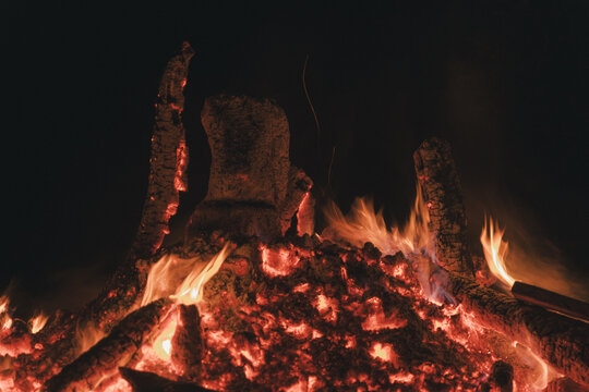 View of a bonfire with glowing embers and burning wood logs at night on Vormsi island, Laane County, Estonia.