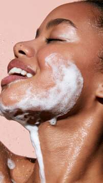Young woman's face covered in white foam, feeling the freshness of a daily cleansing routine while taking care of her skin, emphasizing beauty and personal hygiene