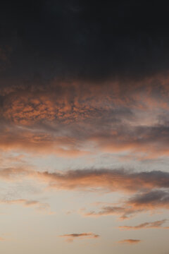 Zosna, Rezekne Municipality, Latvia - 15 July 2024: View of a dramatic sunset sky with vibrant orange and dark grey clouds illuminated by the evening light.
