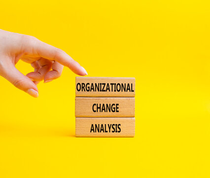 Concept word Organizational Change Analysis on wooden blocks. Businessman hand. Beautiful yellow background. Business and Organizational Change Analysis . Copy space