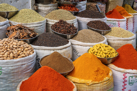 View of colorful spices, herbs, and nuts displayed in large sacks and bowls at Akbari Mandi in Lahore, Punjab, Pakistan.