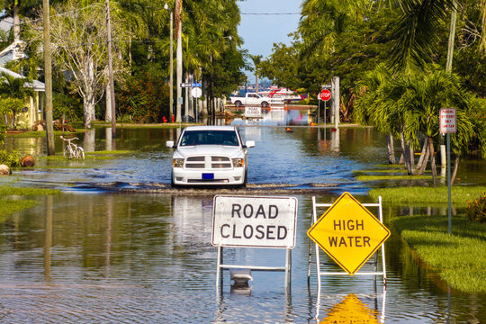 Road under water warning sign. City street closed because of flooding danger blocking driving of cars
