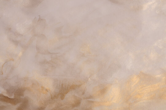Soft wet metallic watercolor ink paper grain texture light and shadow painting wall. Abstract glitter gold, beige marble copy space horizontal background.