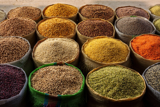View of various colorful sacks filled with assorted grains, lentils, and pulses at the historic Akbari Mandi grain market in Lahore, Punjab, Pakistan.
