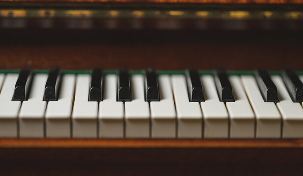 Dark atmospheric piano keys with shallow focus and warm wood.