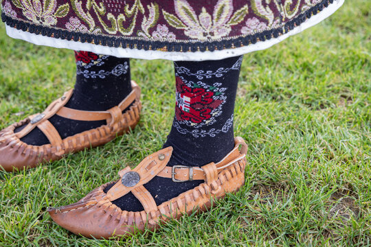 Shoes of a woman in traditional clothing at a Kukeri festival in Bulgaria.