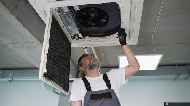 Senior technician repairing air conditioning unit
