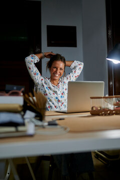 Woman working in a studio, putting her hair up at night