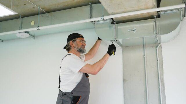 Professional hvac technician installing air duct ventilation system