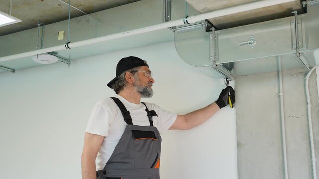 Hvac technician installing ventilation system ductwork