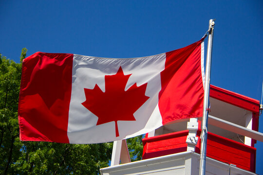 Canadian flag next to a lighthouse