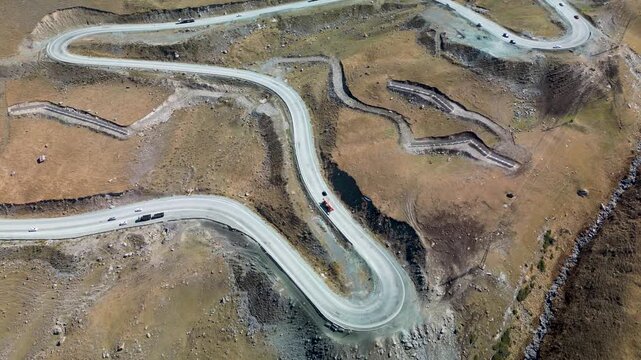 Timelapse aerial drone footage of vehicles winding through the sharp hairpin bends of Too-Ashuu Pass on the Bishkek&ndash;Osh Highway, high in the Tian Shan mountains of Kyrgyzstan