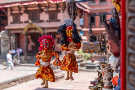 View of traditional Nepali marionettes hanging in front of the historic architecture at Bhaktapur Durbar Square in Bhaktapur, Bagmati Province, Nepal.
