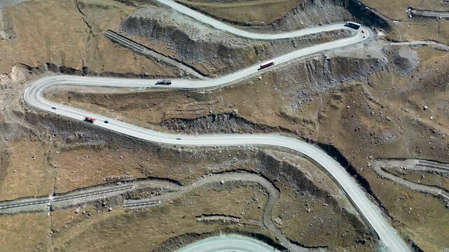 Aerial drone footage of the Too-Ashuu Pass in Kyrgyzstan, featuring the winding Bishkek&ndash;Osh highway with cars and trucks crossing the dramatic Tian Shan mountain pass.