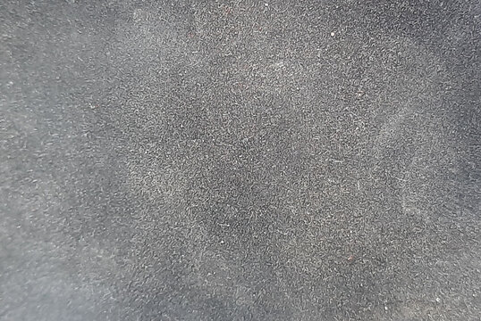Dark gray suede leather texture with fine velvety material and soft matte finish.