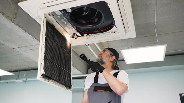 Technician inspecting air conditioner filter and system