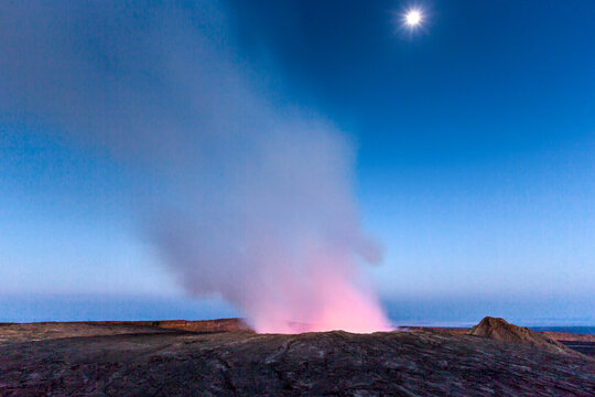 View of the Erta Ale volcano crater emitting a glowing plume of smoke and gas under a clear night sky in Zone 2, Afar, Ethiopia.