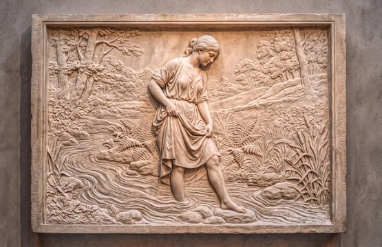 antique style refined bas-relief sculpture of woman bathing in stream with border on stone wall
