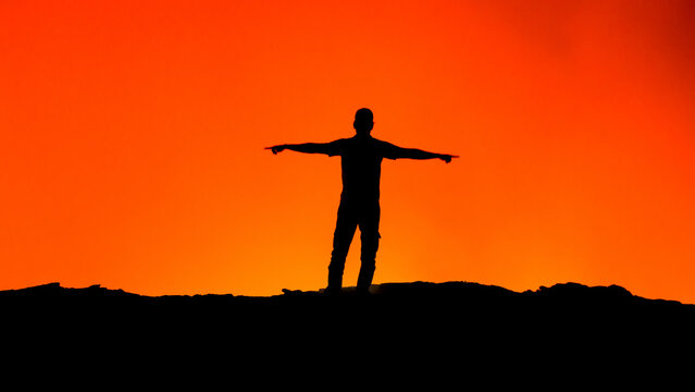 View of a person silhouetted against the glowing molten lava of Erta Ale volcano in Zone 2, Afar, Ethiopia.