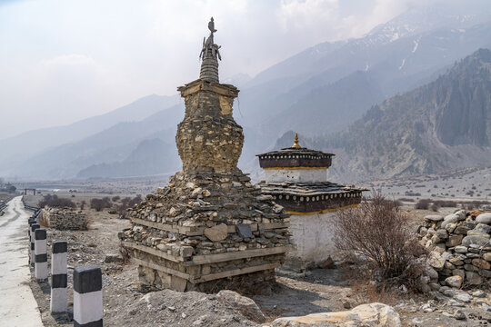 View of the ancient stone chortens at Tanki Manang set against the rugged Himalayan mountain landscape in Manang, Gandaki Province, Nepal.
