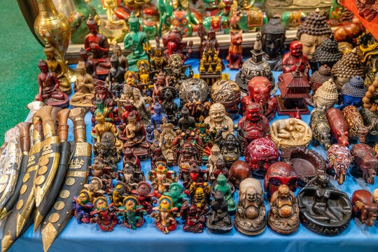 View of various traditional handicrafts, including Buddha statues, Ganesha figurines, and ornate khukuri knives displayed for sale at a shop in Thamel Marg, Kathmandu, Bagmati Province, Nepal.