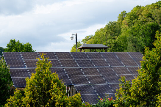 Solar panels on a building in an area surrounded by trees during daytime
