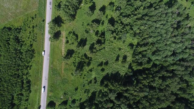 Drone flying backward tilting upward over road