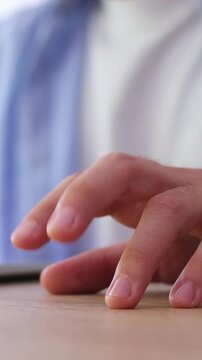 Close-up of a restless man's hand, his fingers drumming impatiently on a wooden table. This gesture indicates boredom, stress, or anxiety while waiting during an important meeting or interview