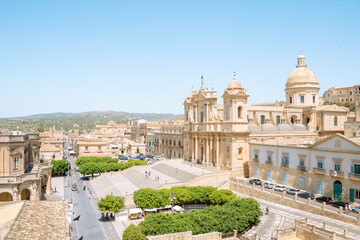Naklejka premium Panoramic high angle view of Sicilian baroque Noto Cathedral, Cattedrale di San Nicolò in Sicily, with yellowing limestone shot from Chiesa di Santa Chiara