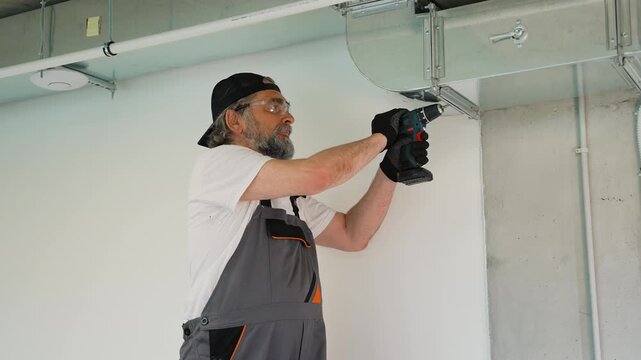 Hvac technician installing metal air duct ventilation