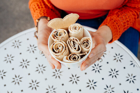Close-up of woman presenting chocolate rolled ice cream with heart wafer
