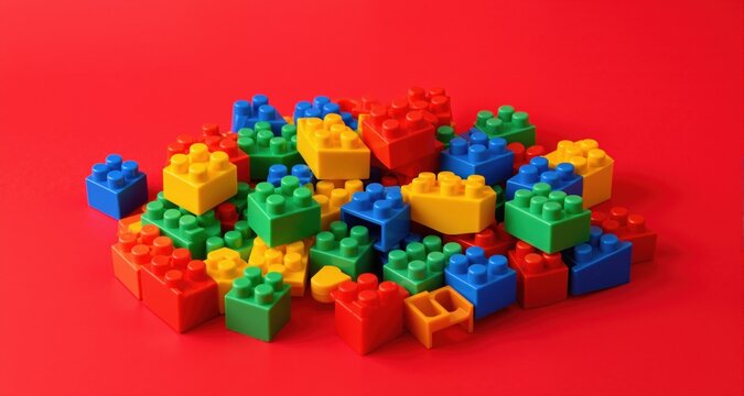 Colorful plastic building blocks on red background
