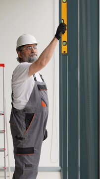 Construction worker using spirit level on wall