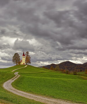 Undulating dirt trail going uphill to the Baroque, XVII c.Saint Thomas church (Cerkev svetega Tomaza) in Gorenji Vrsnik village. Idrija-Slovenia-189