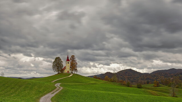 Undulating dirt trail going uphill to the Baroque, XVII c.Saint Thomas church (Cerkev svetega Tomaza) in Gorenji Vrsnik village. Idrija-Slovenia-190