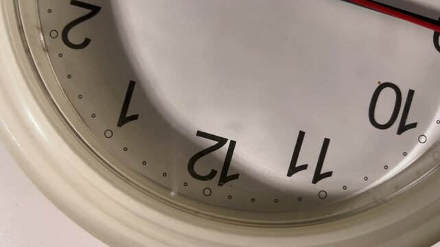 Top view of clock face rotating on turntable with second hand stuck due to low battery