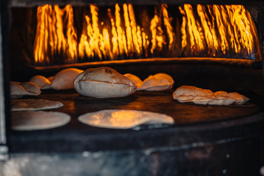 View of traditional flatbread baking in a wood-fired oven with visible flames in Siwa, Marsa Matruh Governorate, Egypt.