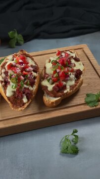 Authentic Mexican gastronomy molletes topped with melted cheese, chorizo and homemade pico de gallo