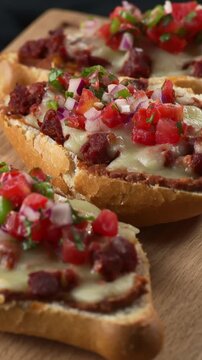 Close up of authentic Mexican food molletes with refried beans, cheese, chorizo and pico de gallo