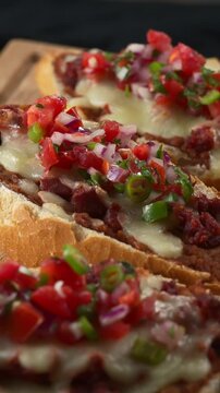 Mexican Appetizer. Molletes with Chorizo topped with Pico de Gallo