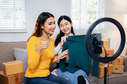 Two women are sitting on a couch, one of them holding a green sh