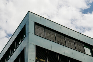 Fototapeta premium Modern corporate office building corner with dark metallic facade in Rotkreuz