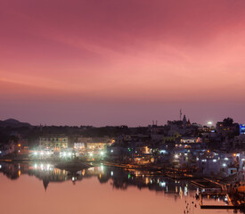 Fototapeta premium Scene featuring sacred Puskhar lake (Sagar) and ghats of town Pushkar in twilight in the evening, Rajasthan, India