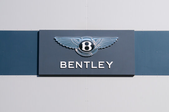 Bentley Motors luxury car brand logo sign on dealership building in Grancia, Switzerland