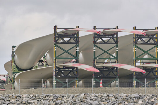 View of wind turbine blades stacked in metal transport frames on the quay of the harbor in Esbjerg, Syddanmark, Denmark.
