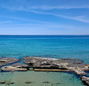 Ancient Roman fish ponds carved into coastal rocks in Calpe Spain surrounded by turquoise Mediterranean water