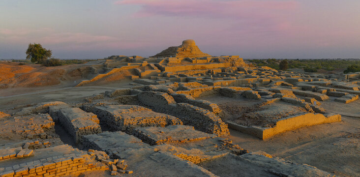 View of the ancient brick ruins and archaeological structures of the historic city of Mohenjo-daro at sunset in Mohenjo-daro, Sindh, Pakistan.